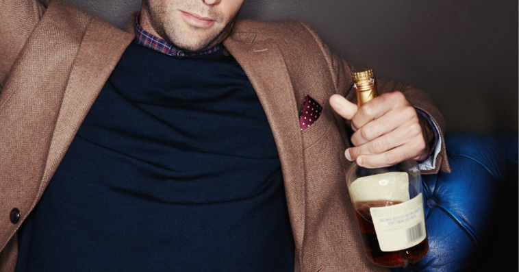 Man holding a bottle of whiskey