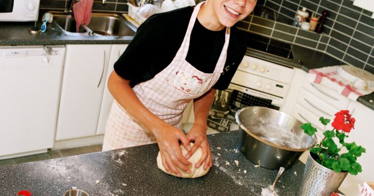 A teenage boy works with dough