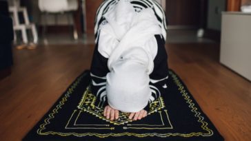 A muslim woman prays on a carpet