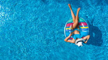 Teenage girl floating in a pool.