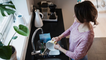 Frustrated woman washing dishes