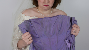 Angry bride holding up bridesmaid's dress