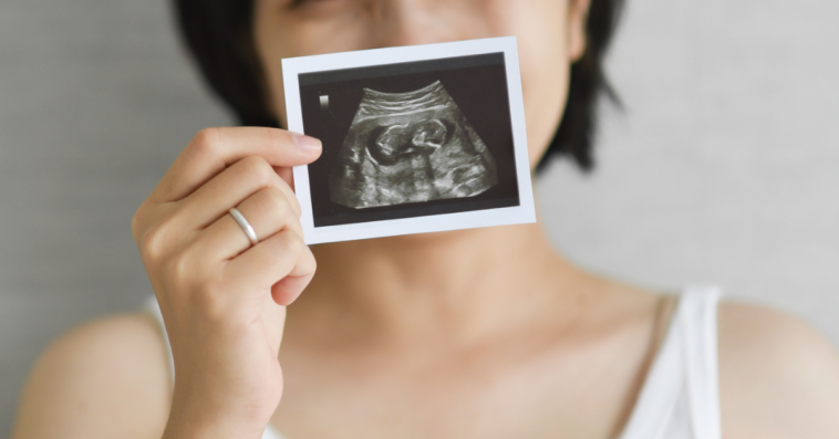 Excited woman holding ultrasound picture