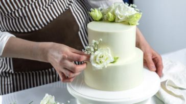 A woman works on a wedding cake
