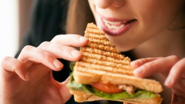 A woman eats a sandwich
