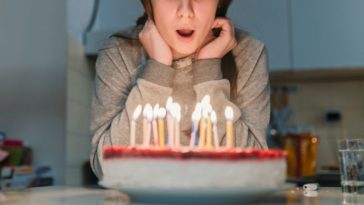 A young girl blows out candles on her birthday cake