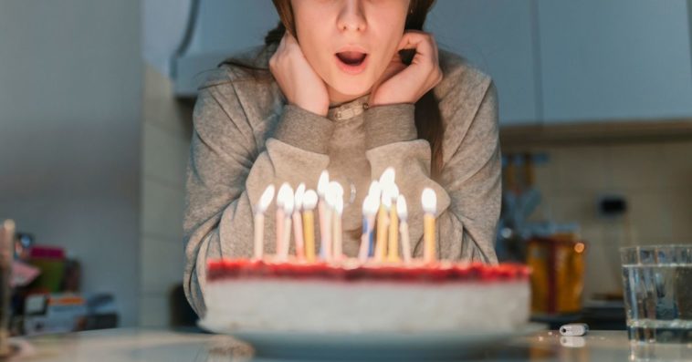 A young girl blows out candles on her birthday cake