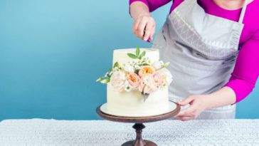 A baker prepares a wedding cake