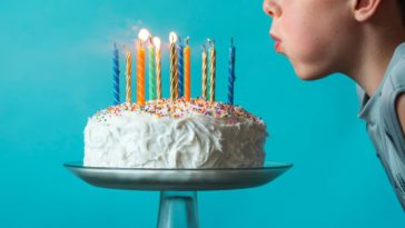A little boy blows out birthday candles
