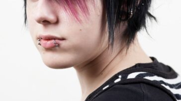 Photo of an emo girl, black and pink hair and mouth rings