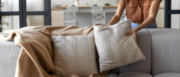 woman placing pillows on sofa
