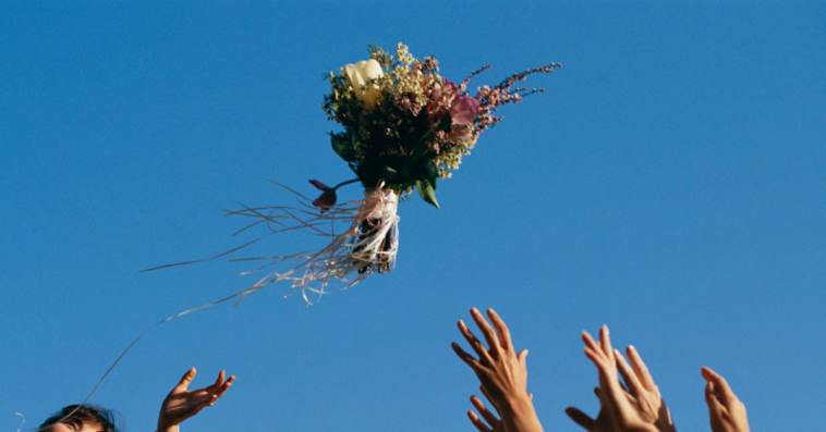 a bride throwing a bouquet at wedding.