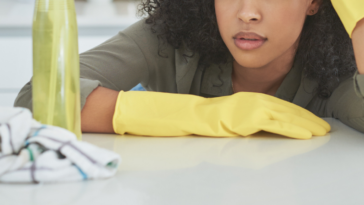 Woman unhappily cleaning kitchen counter