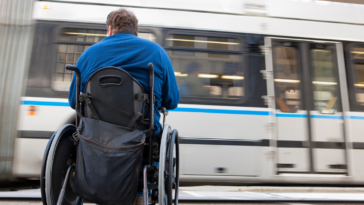 Man in wheelchair waiting for public bus