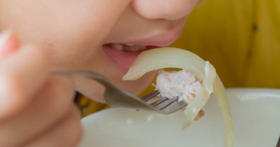 Young child eating an onion