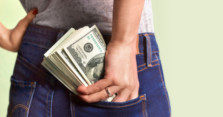 Woman stuffing money in her back pocket