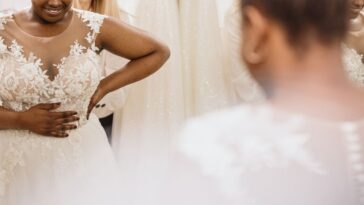 A bride looks into the mirror admiring herself in her dress