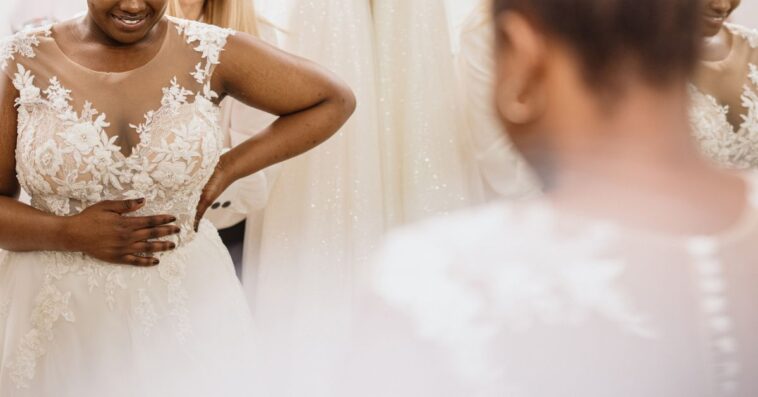A bride looks into the mirror admiring herself in her dress