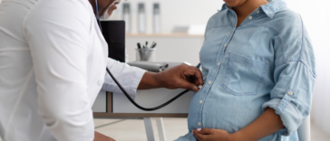 Male doctor examining pregnant woman