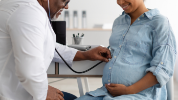Male doctor examining pregnant woman