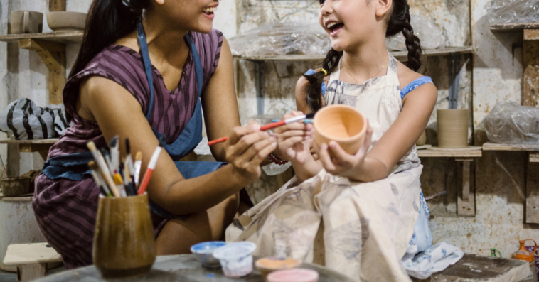 Woman doing art with young girl