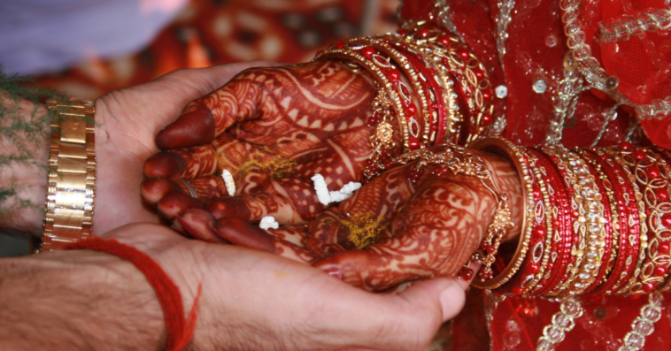 Indian bride holding hands with groom