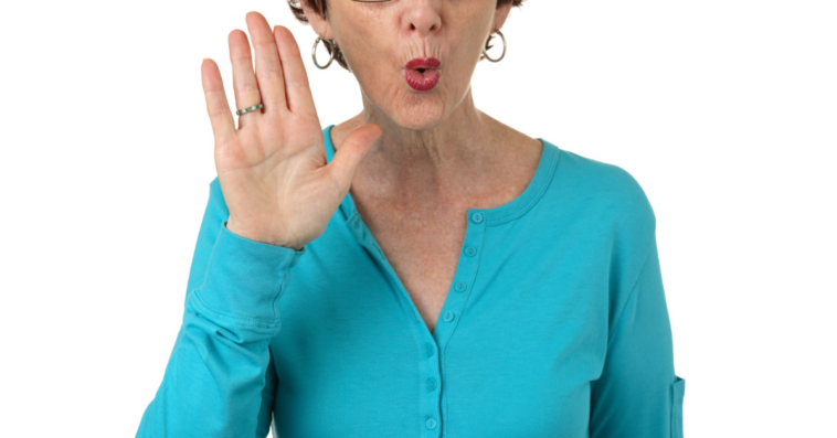 Offended older woman holding up her hand in disagreement