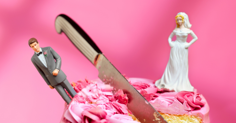 a wedding cake with a knife between the bride and groom cake toppers