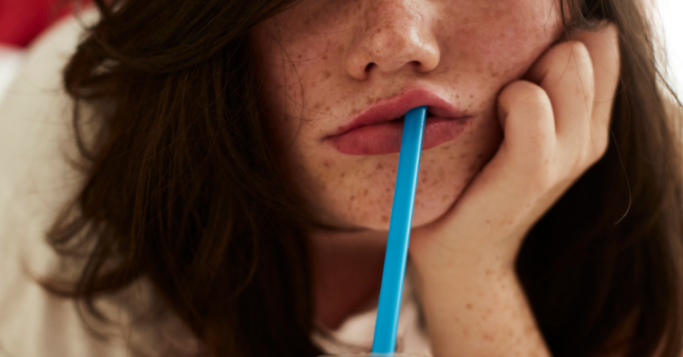 Woman bored with drinking through a straw