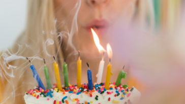 Woman blowing out birthday candles.