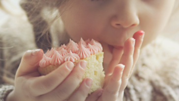 little girl eating a cupcake.