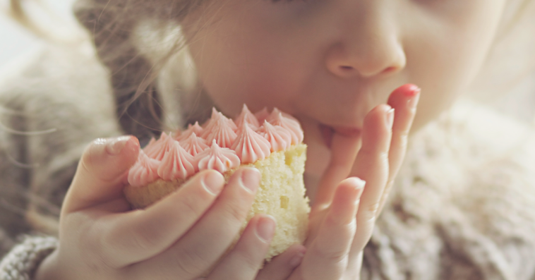 little girl eating a cupcake.