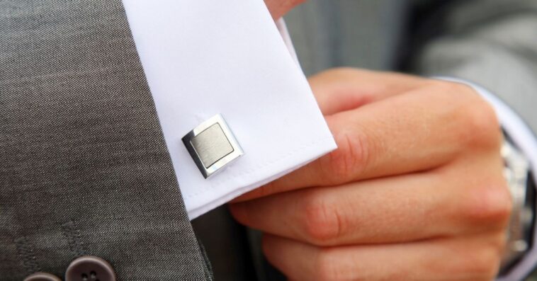 A man puts on cufflinks