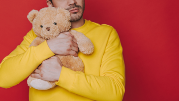 Man cuddling teddy bear
