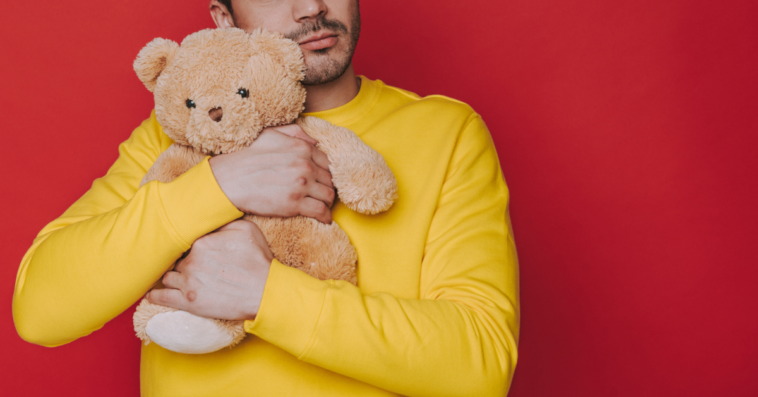 Man cuddling teddy bear