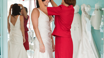 Woman with daughter while trying on bridal dresses