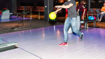 Teen boy bowling.
