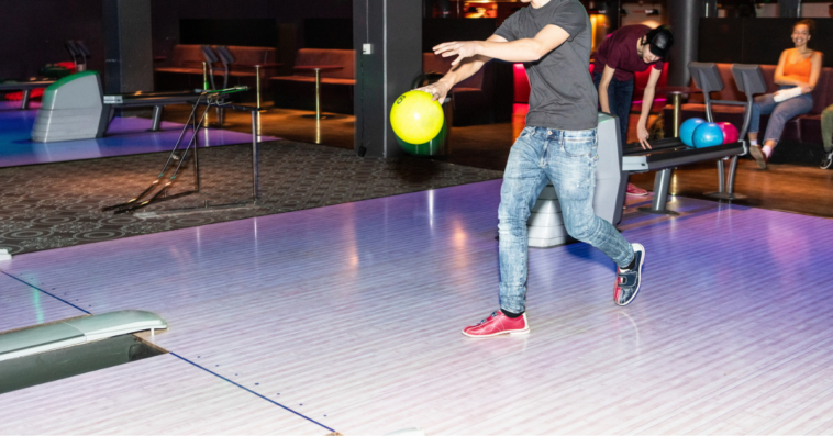 Teen boy bowling.