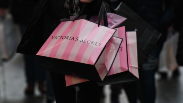 Woman carrying Victoria's Secret shopping bags.