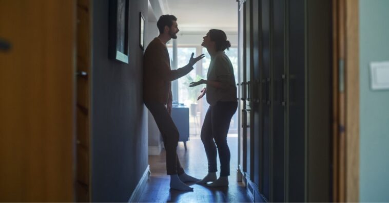 A couple argues in a hallway, in a home