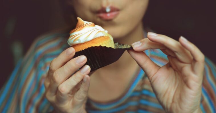 A woman eats a cupcake