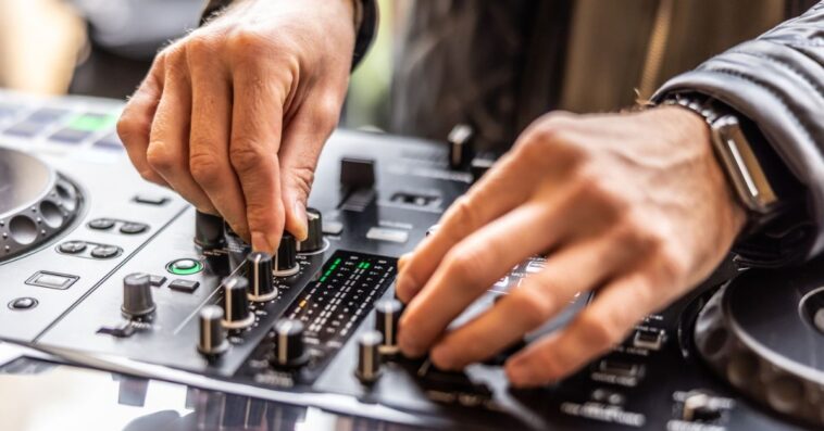 A DJ's hands mix the tables