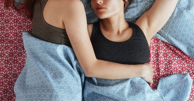 Two women lie in bed together