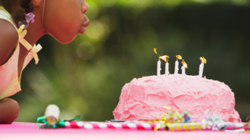 Young girl blowing out birthday candles