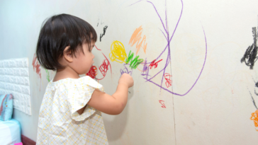 Toddler coloring on the wall
