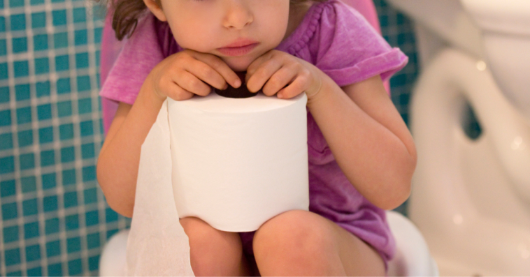 Young girl sitting on toilet