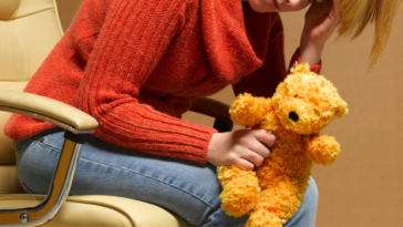 Grieving mother holding teddy bear