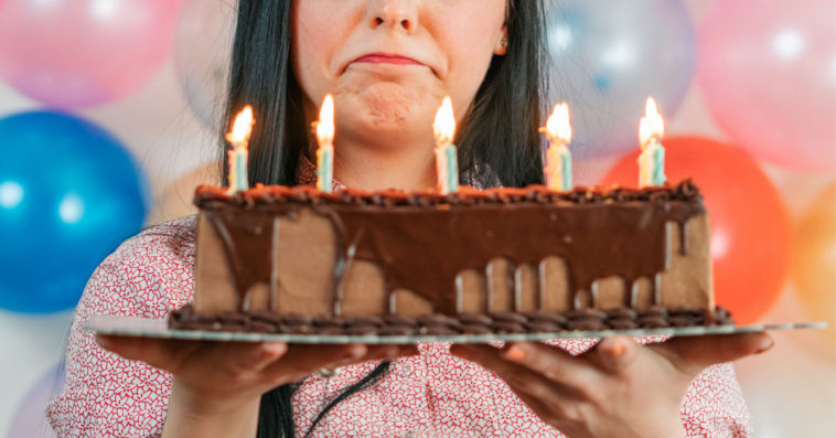 Teenage girl sad while looking at birthday cake