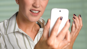 Woman looking angrily at her cell phone