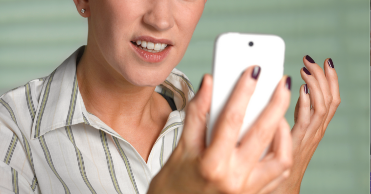 Woman looking angrily at her cell phone